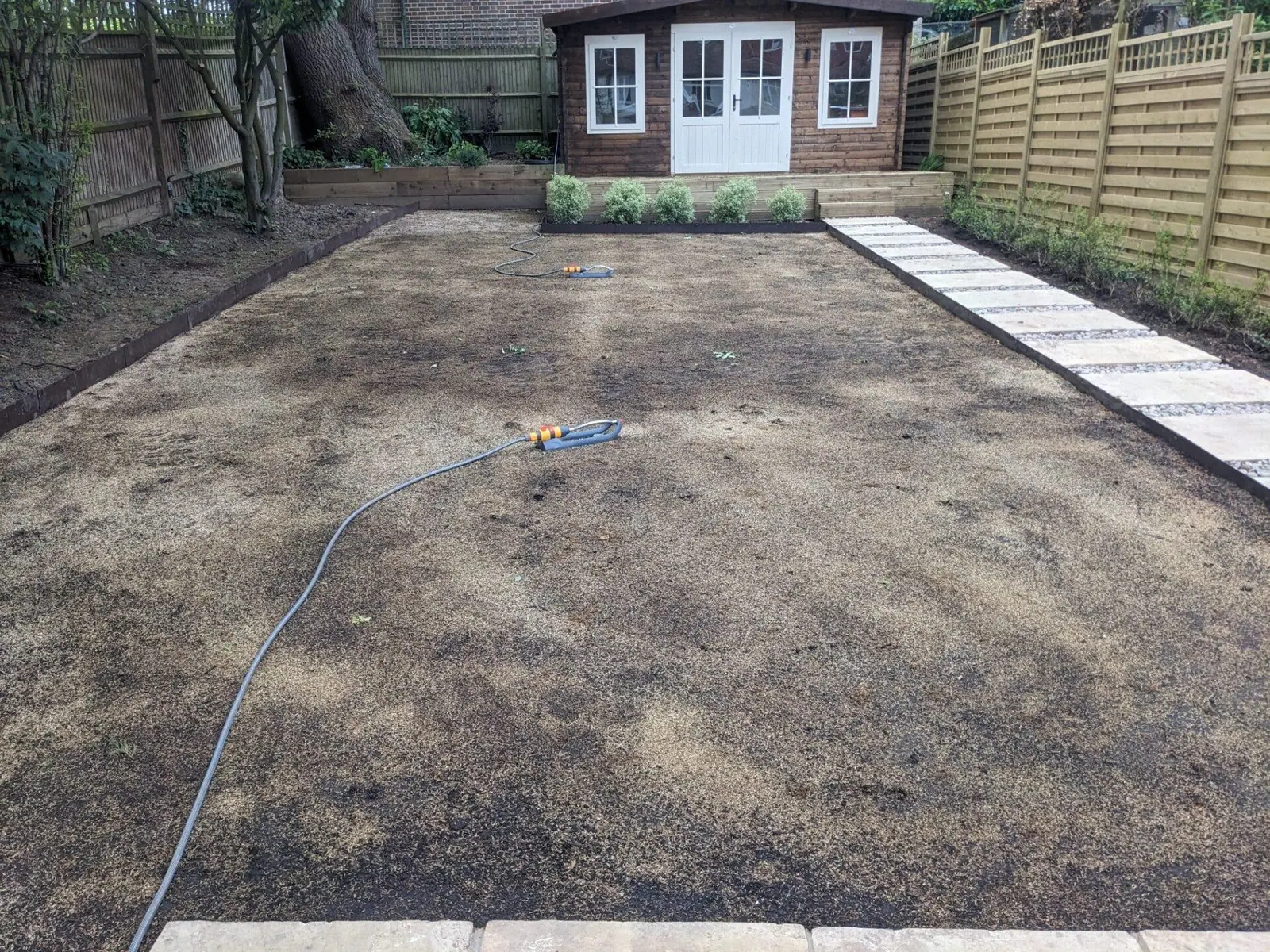 The same garden before turfing: soil levelled and raked ready for new turf